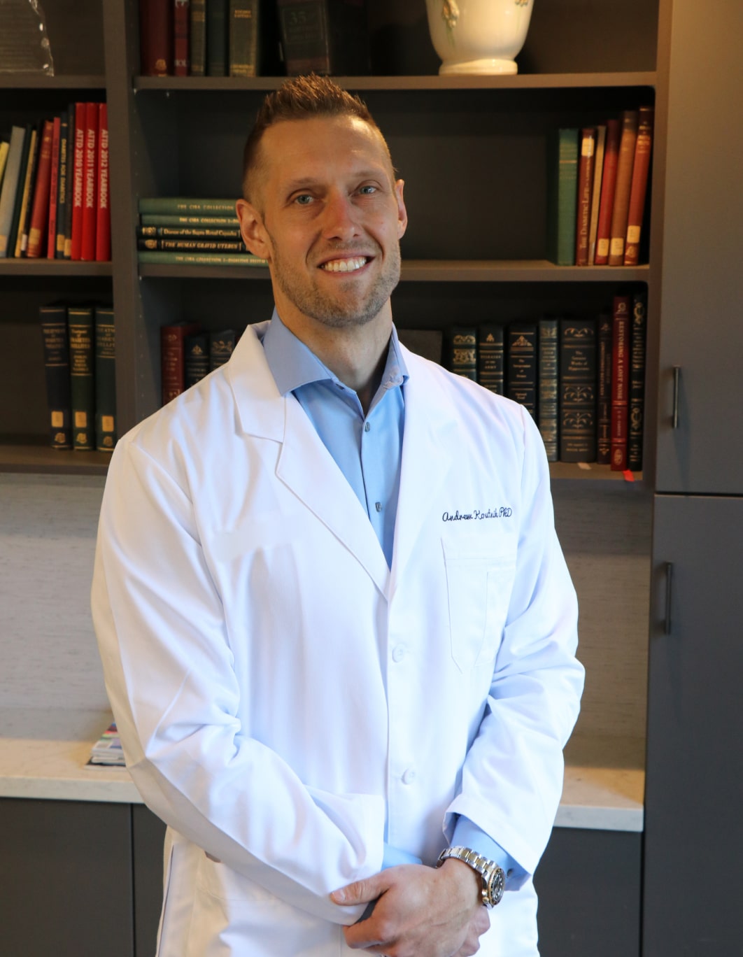 Dr. Andrew Koutnik, Ph.D., in a white lab coat
